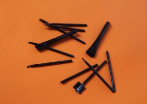 a group of black pens sitting on top of an orange surface